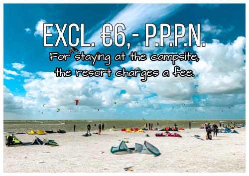 a group of people on a beach flying kites at Chalet D12 - Camping it Soal in Workum