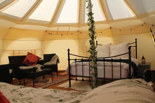 a bedroom with a canopy bed and a chair at Tal-y-fan farm 6m stargazer tent in Bridgend