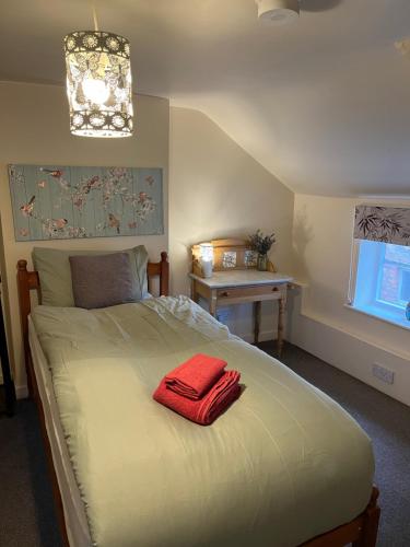a bedroom with a bed with a red towel on it at Red lion flat in Coltishall