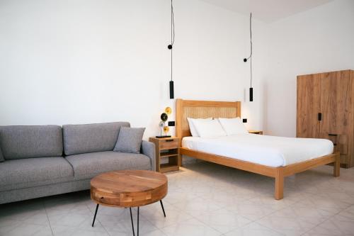 a bedroom with a bed and a couch and a table at Centrio Fira Suites in Fira