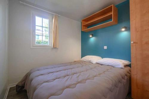 une chambre avec un grand lit avec un mur bleu dans l'établissement Camping 5 étoiles - Piscine - eeaibb, à Saint-Georges-dʼOléron