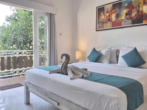 ein ausgestopfter Schwan, der auf einem Bett in einem Schlafzimmer sitzt in der Unterkunft The shortcut rooms in Canggu