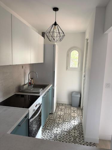 une cuisine avec un évier et un réfrigérateur dans l'établissement Central, terrasse, proche plage et toute proximité, à Cavalaire-sur-Mer