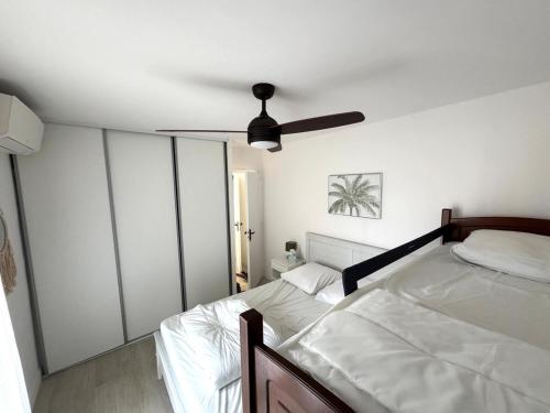 une chambre avec un lit et un ventilateur de plafond dans l'établissement Central, terrasse, proche plage et toute proximité, à Cavalaire-sur-Mer