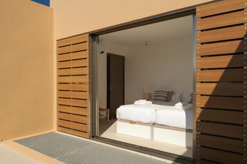 una camera da letto con un letto e una porta scorrevole in vetro di Salgados Premium Beach Villa by DA'Home ad Albufeira