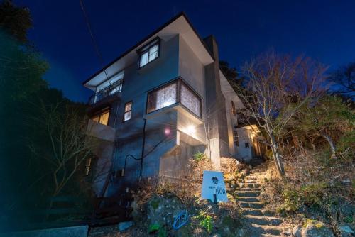 a blue house with stairs leading up to it at night at 箱根御泊処-TOGA- 045h in Hakone