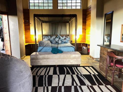 un dormitorio con una cama con dosel en Anahata Nature Resort, en Hartbeespoort