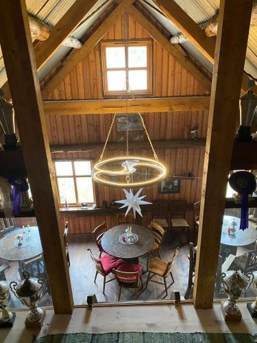 an attic room with a table and a chandelier at Lysefjorden og Prekestolen Unik og koselig leilighet i stallbygning in Sandnes