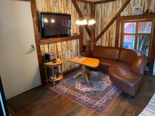 a living room with a leather couch and a table at Lysefjorden og Prekestolen Unik og koselig leilighet i stallbygning in Sandnes