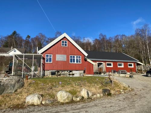 a red barn with white windows on a house at Lysefjorden og Prekestolen Unik og koselig leilighet i stallbygning in Sandnes