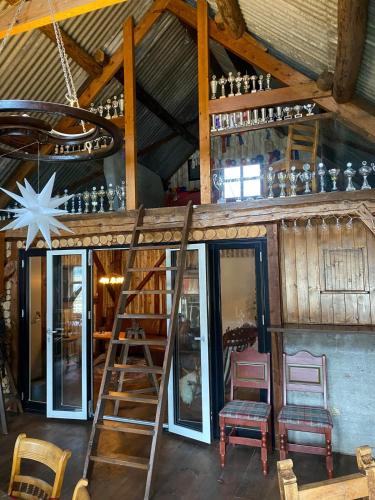 a room with a bar with a ladder and chairs at Lysefjorden og Prekestolen Unik og koselig leilighet i stallbygning in Sandnes