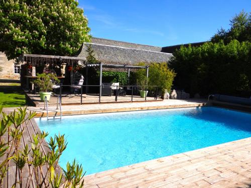 a swimming pool in a yard with a table and chairs at La maison de Gilbert Jacuzzi Piscine chauffée in Chaudes-Aigues