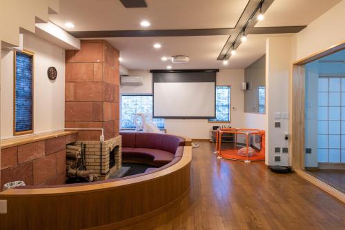 a living room with a couch and a projection screen at 箱根御泊処-TOGA- 045h in Hakone