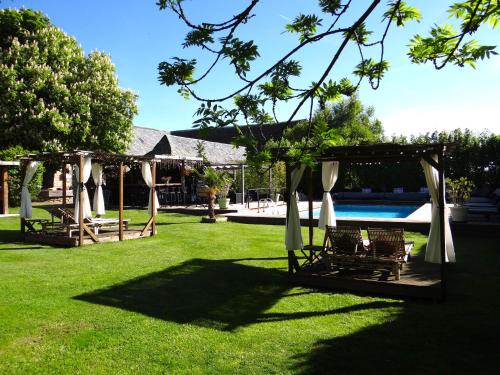a group of chairs under a gazebo next to a pool at La maison de Gilbert Jacuzzi Piscine chauffée in Chaudes-Aigues