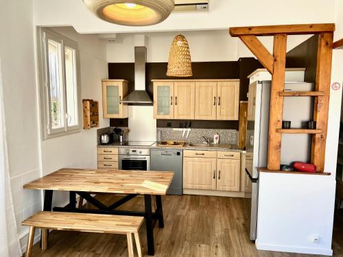 une cuisine avec une table en bois et un réfrigérateur dans l'établissement Charmant appartement 3 chambres à 100m de la plage centrale, à Canet
