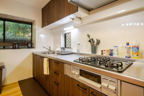 a kitchen with a stove and a sink at 箱根御泊処-TOGA- 045h in Hakone