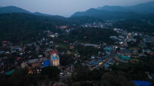 an overhead view of a city with mountains in the background at The Cardamom Thekkady in Thekkady