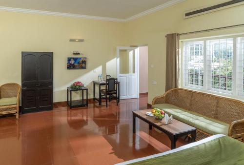 a living room with a couch and a table at The Cardamom Thekkady in Thekkady