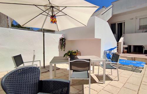 a table and chairs with an umbrella on a patio at L' Appoggio - Monolocale Eco-sostenibile A Due Passi Dal Centro Storico in Corsano