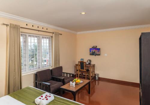 a living room with a bed and a couch at The Cardamom Thekkady in Thekkady