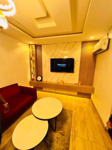 a room with a couch and a table and a tv at Shabby Luxury Apartment in Lagos