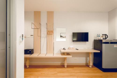 a room with a table and a desk with a television at Di Yana Patong in Patong Beach