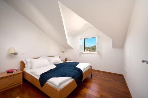 a bedroom with a bed and a window at Sun Spalato Maslinica in Maslinica
