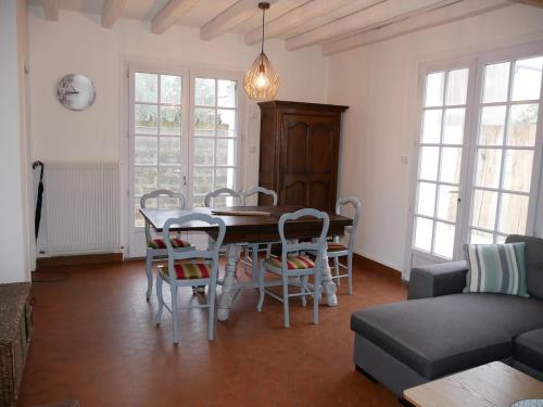 un salon avec une table, des chaises et un canapé dans l'établissement Maison au calme proche plage, centre à 2 min à pied, à La Tranche-sur-Mer