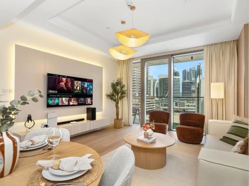 a living room with a couch and a tv at The Dubai Mall Suite Luxury 1-Bed Near Burj Khalifa in Dubai