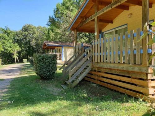 a wooden house with a porch and a door at Camping 3 étoiles - ccaiaah in Monoblet
