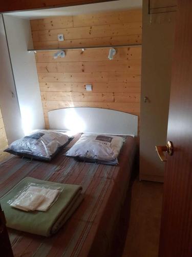 two beds in a bedroom with a wooden wall at Camping 3 étoiles - ccaiaah in Monoblet