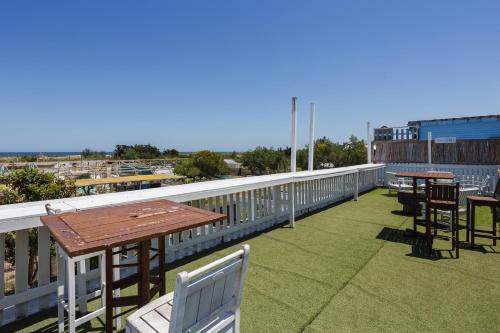 a patio with tables and chairs on a balcony at Oliwood Beach - Fama in Oliva