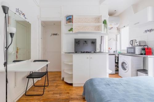 a small white kitchen with a bed and a desk at PARIS Vincennes authentique -`ღ in Vincennes