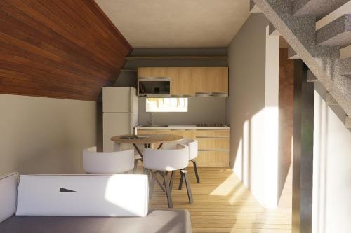 a small kitchen with a table and white chairs at Casitas Rincon Village in Santa Bárbara de Samaná
