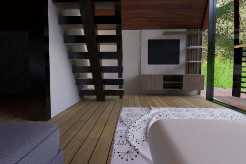 a living room with a bed and a tv at Casitas Rincon Village in Santa Bárbara de Samaná