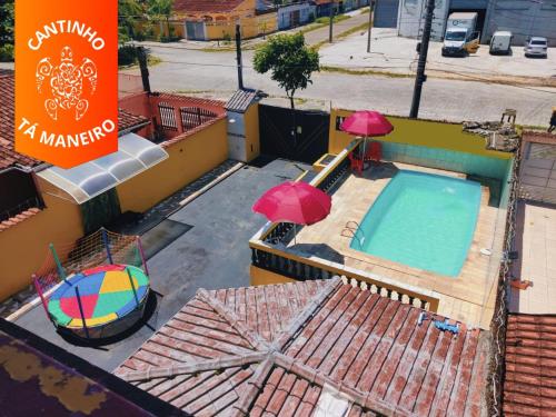 an overhead view of a swimming pool with umbrellas at Cantinho Tá Maneiro in Mongaguá