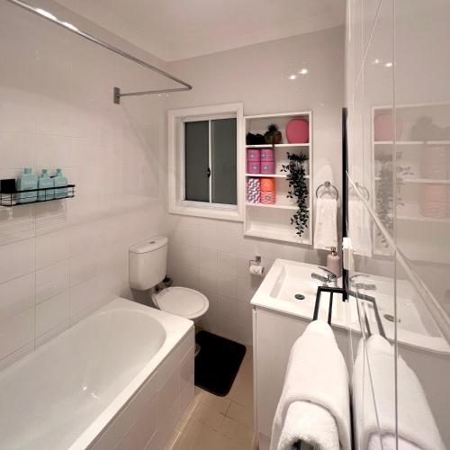 a bathroom with a tub and a toilet and a sink at The Alice, Mittagong in Mittagong