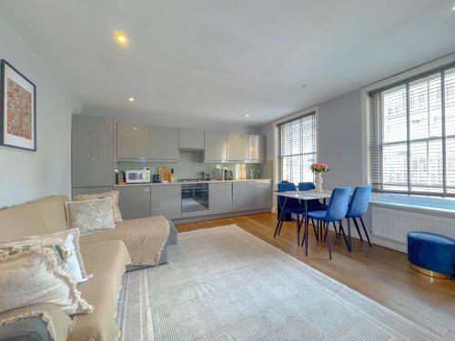 a living room with a couch and a table with blue chairs at Pass the Keys Central 2 Bed 2 Bath Duplex in London