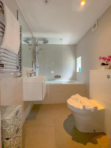 a bathroom with a tub and a toilet and a sink at Pass the Keys Central 2 Bed 2 Bath Duplex in London