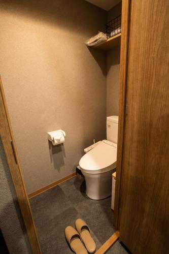a bathroom with a toilet and a pair of slippers at Nestry Asakusa 502号室 in Tokyo