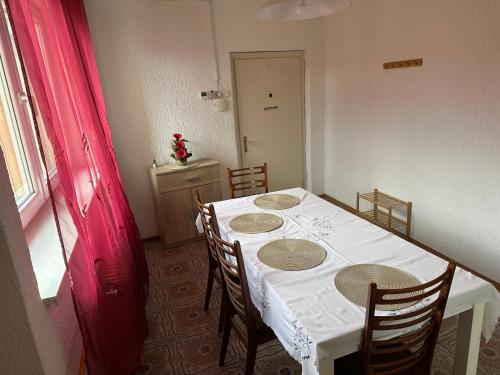 a dining room table with a white table cloth and chairs at Apartma Pri Kosu in Slovenska Bistrica