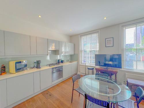a kitchen with a glass table and chairs in it at Pass the Keys Stylish 1 bed Soho Flat in London