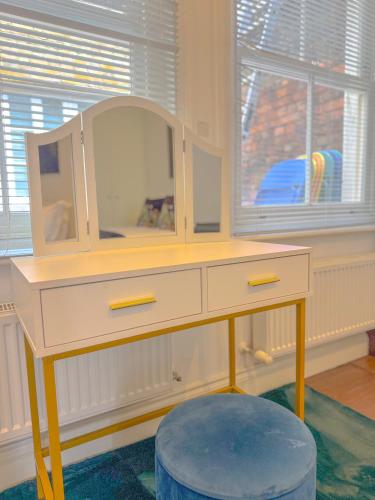 a desk with a mirror and a stool in a room at Pass the Keys Stylish 1 bed Soho Flat in London