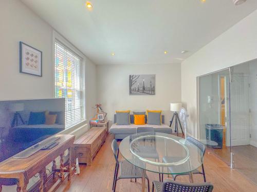 a living room with a couch and a glass table at Pass the Keys Stylish 1 bed Soho Flat in London