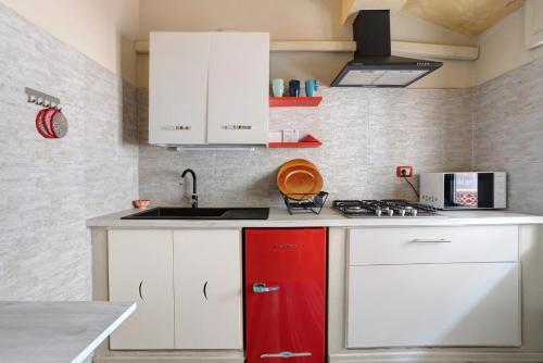 a kitchen with white cabinets and a red refrigerator at La Perla Del Lido a Camaiore in Lido di Camaiore
