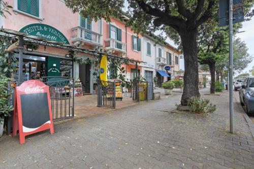 a cobblestone street with a cocacola sign in front of a building at La Perla Del Lido a Camaiore in Lido di Camaiore