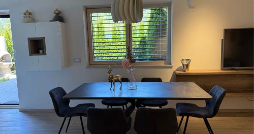 a dining room with a table and chairs and a tv at Vila Mojca SKI IN&OUT - Apartmaji Lena in Kranjska Gora