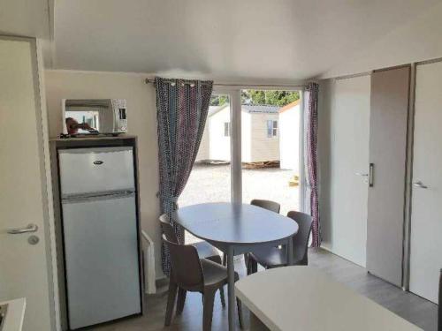 a dining room with a table and chairs and a window at Camping 3 étoiles - ccaiaah in Monoblet