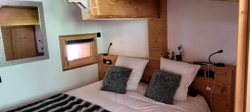 a bedroom with a bed with two pillows on it at Roof top Moutain view direct access Morzine Avoriaz in Montriond