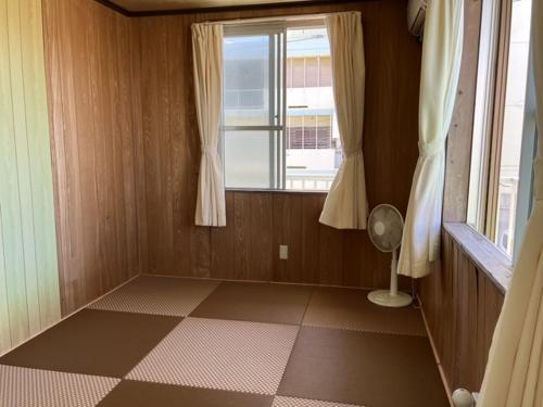 a small room with a window and a fan at みどり荘 midorisou in Ishigaki Island